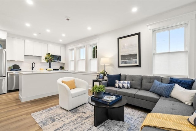 living room featuring sink and light hardwood / wood-style floors