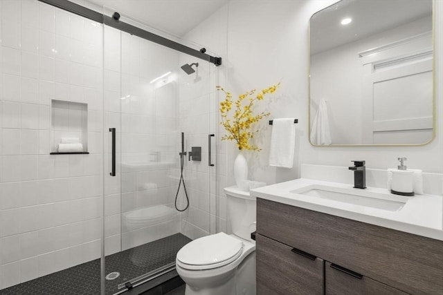 bathroom with vanity, toilet, and a shower with shower door