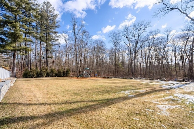 view of yard with playground community and a view of trees