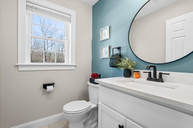 bathroom featuring toilet, tile patterned flooring, baseboards, and vanity