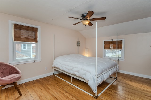 bedroom featuring ceiling fan, lofted ceiling, light hardwood / wood-style flooring, and multiple windows