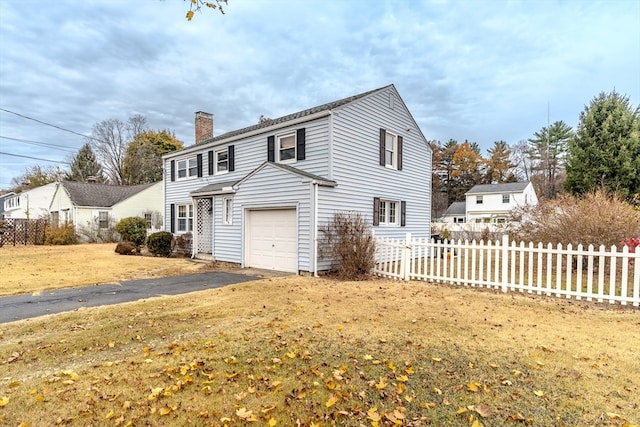 view of front of property featuring a garage and a front lawn