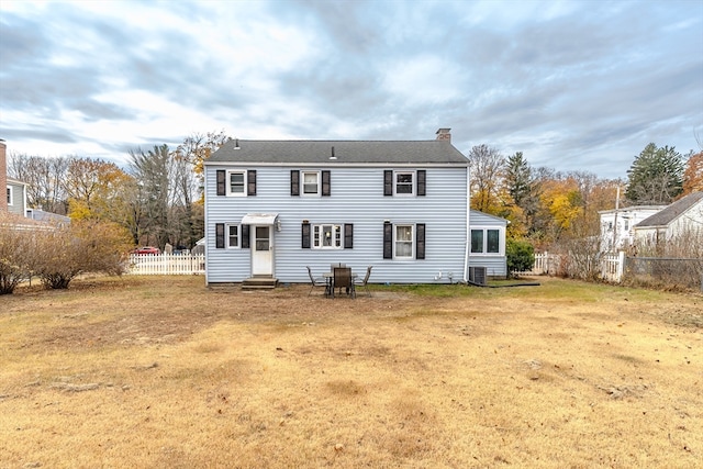 rear view of house featuring a yard and central AC unit