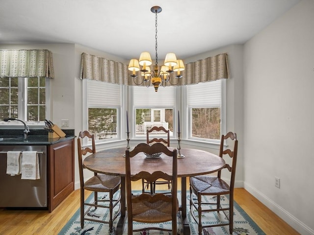 dining area with a chandelier, light wood-type flooring, and baseboards