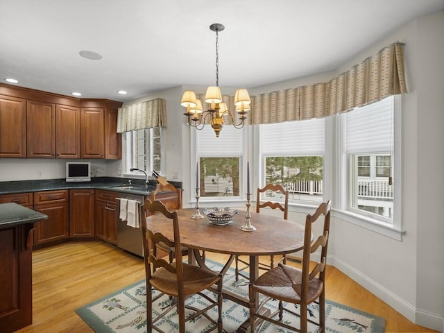 dining room featuring light wood-type flooring, recessed lighting, baseboards, and an inviting chandelier