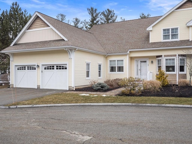 view of front of home with a shingled roof, an attached garage, and aphalt driveway