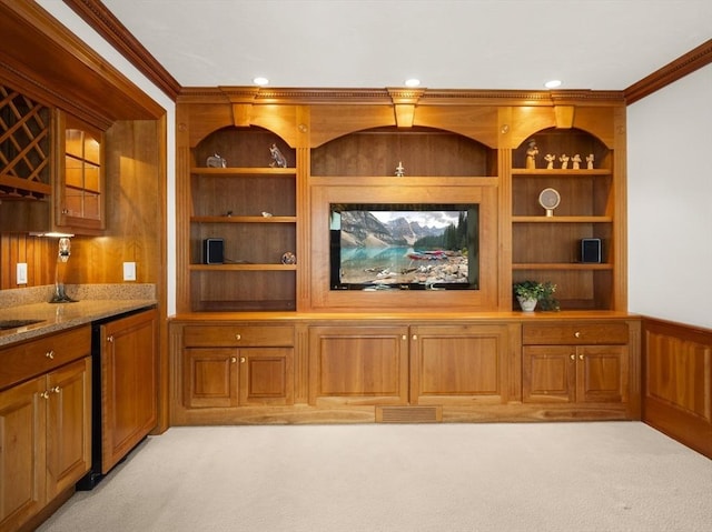 bar with ornamental molding, indoor wet bar, built in features, and light colored carpet