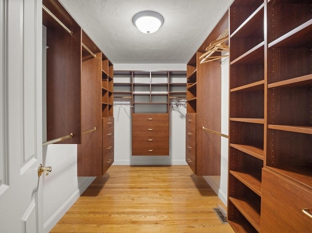 spacious closet with light wood-style floors and visible vents