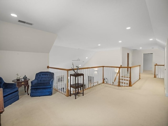 sitting room featuring carpet, lofted ceiling, recessed lighting, visible vents, and an upstairs landing