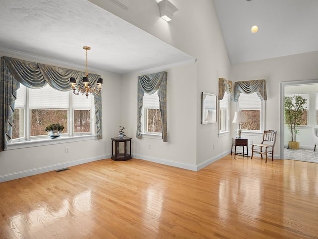 unfurnished dining area with baseboards, visible vents, a chandelier, and wood finished floors