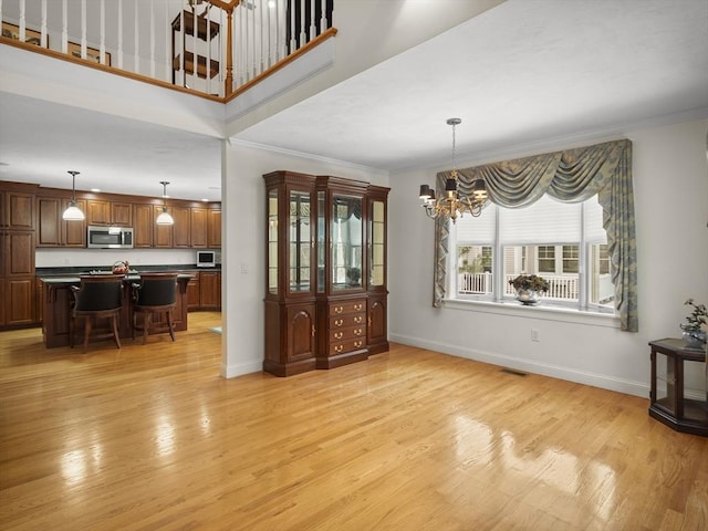 dining area with visible vents, crown molding, light wood-style flooring, and baseboards