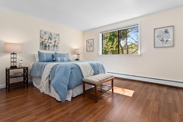 bedroom with baseboard heating, wood finished floors, and baseboards