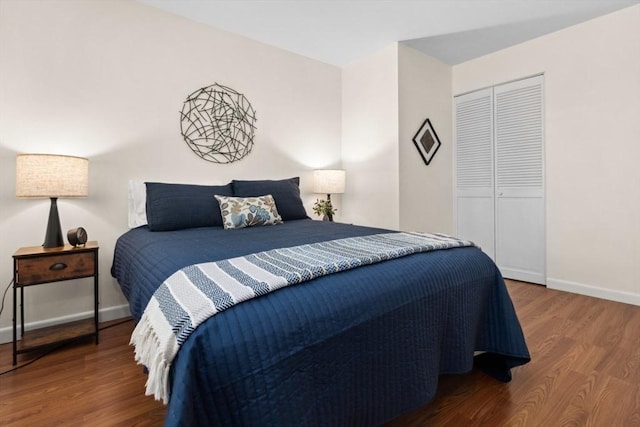 bedroom with wood finished floors, a closet, and baseboards