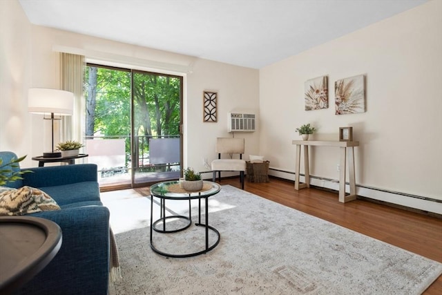 living area with wood finished floors, an AC wall unit, and baseboard heating