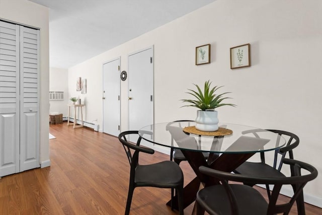 dining room featuring baseboard heating and wood finished floors