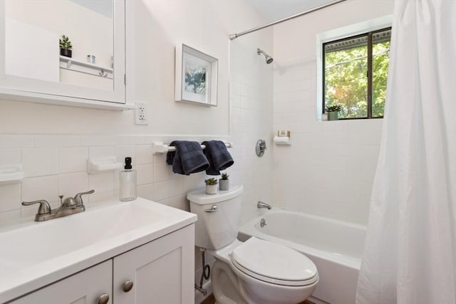 bathroom featuring toilet, shower / bath combination with curtain, vanity, tile walls, and wainscoting