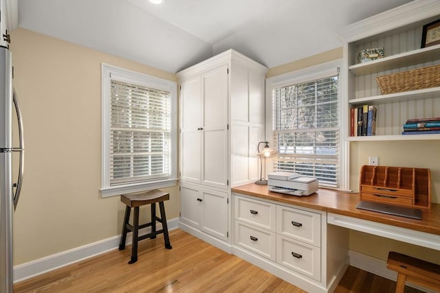 mudroom with vaulted ceiling, built in desk, and light hardwood / wood-style floors