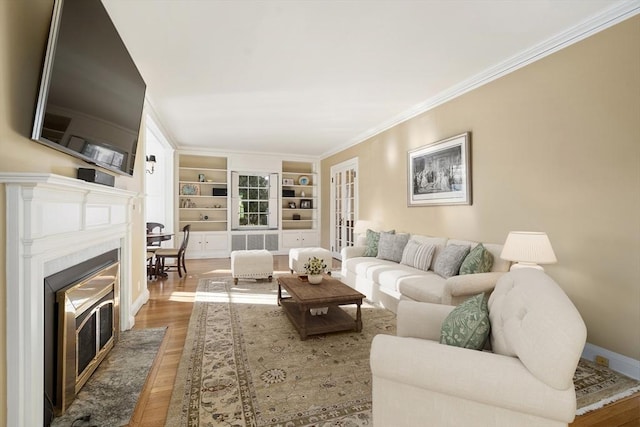 living room with wood-type flooring, crown molding, and built in shelves