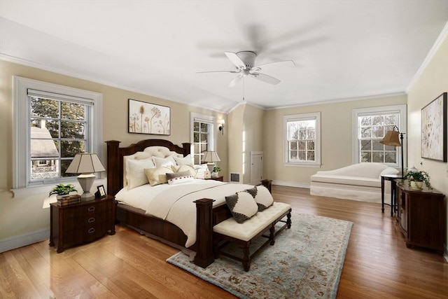 bedroom featuring hardwood / wood-style floors, ornamental molding, and ceiling fan