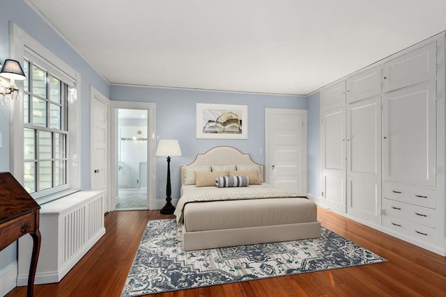 bedroom with crown molding, dark hardwood / wood-style floors, and ensuite bathroom