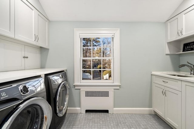 laundry room with sink, light tile patterned floors, washer and clothes dryer, radiator heating unit, and cabinets