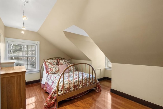 bedroom with lofted ceiling and hardwood / wood-style floors