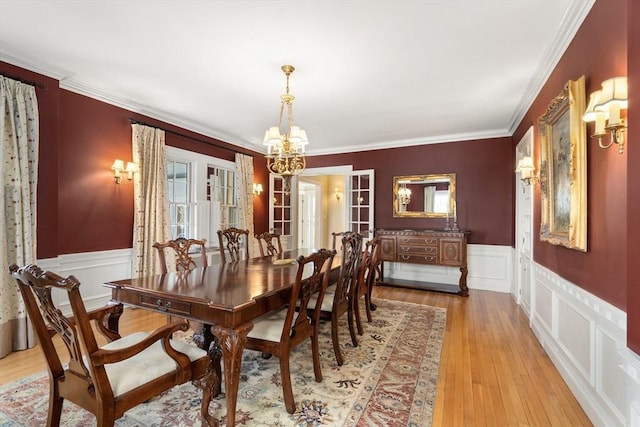 dining room with a notable chandelier, crown molding, and light hardwood / wood-style floors