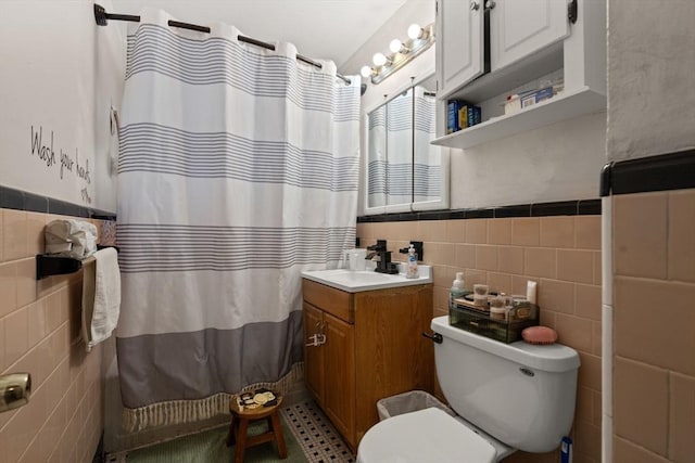 bathroom with vanity, tile walls, and toilet