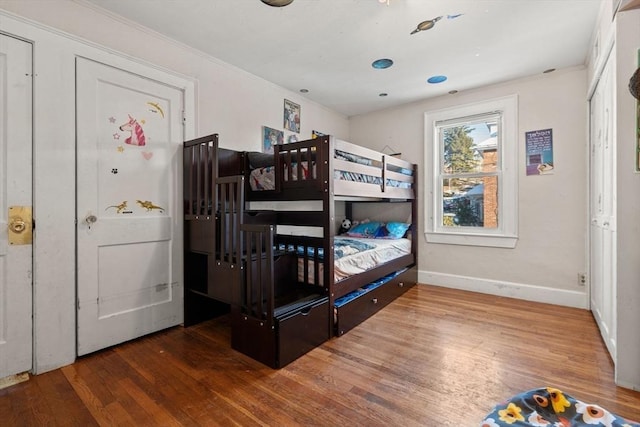 bedroom with crown molding and hardwood / wood-style flooring