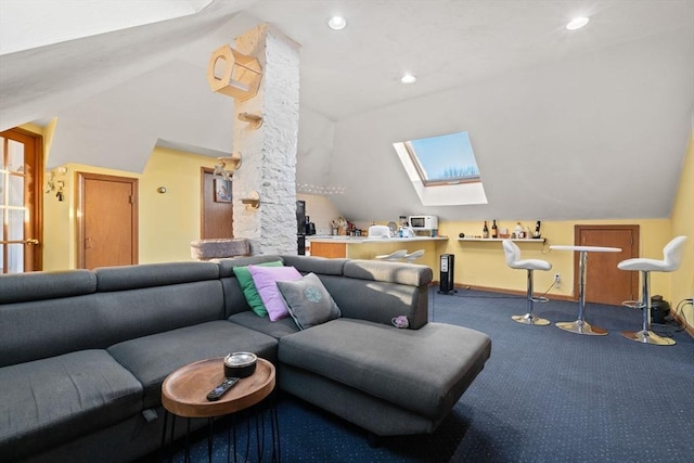 living room with vaulted ceiling with skylight and carpet floors