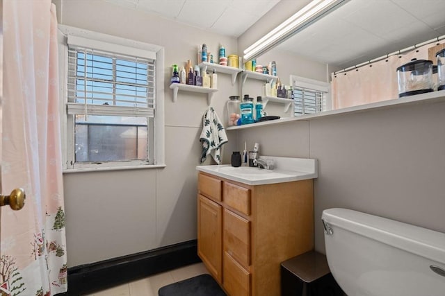 bathroom featuring vanity, tile patterned flooring, and toilet