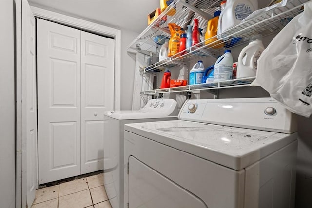 clothes washing area with washer and dryer and light tile patterned floors