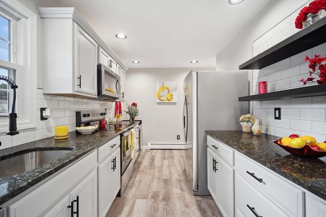 kitchen featuring decorative backsplash, sink, white cabinets, and appliances with stainless steel finishes