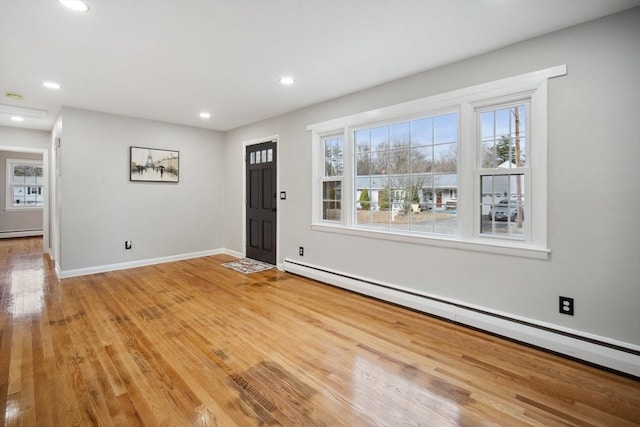 entryway with a wealth of natural light, a baseboard radiator, and hardwood / wood-style flooring