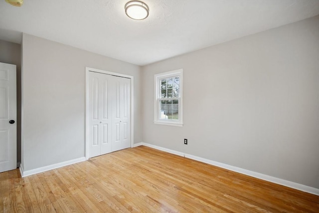 unfurnished bedroom with light hardwood / wood-style flooring and a closet