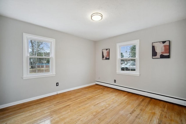 empty room with light hardwood / wood-style flooring and a baseboard radiator