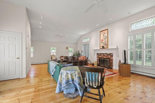 181 Pleasant St, Yarmouth, MA 02664 - living area featuring a ceiling fan, light wood-type flooring, a baseboard radiator, a fireplace, and vaulted ceiling