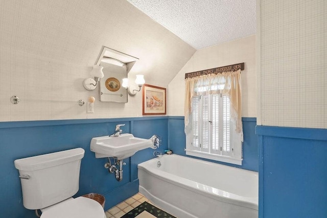 181 Pleasant St, Yarmouth, MA 02664 - bathroom featuring a garden tub, lofted ceiling, a textured ceiling, and wainscoting