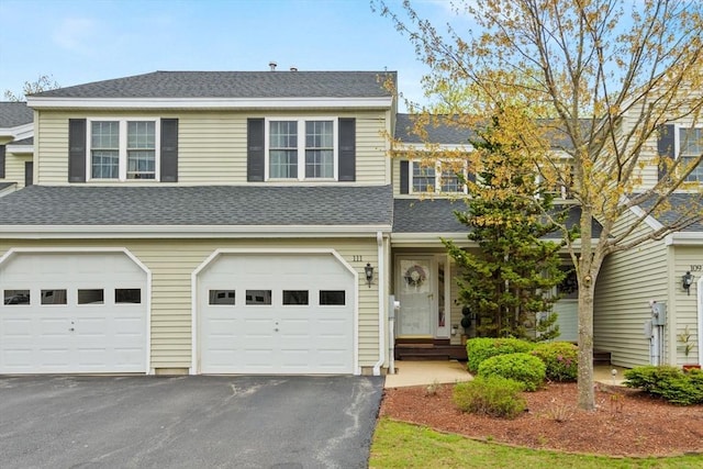 view of front of home featuring asphalt driveway, a shingled roof, and a garage