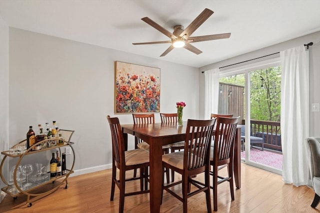 dining area featuring ceiling fan, light wood-style floors, and baseboards