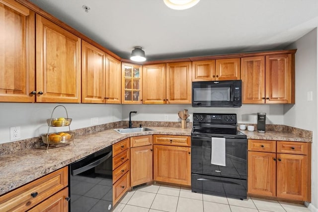 kitchen with black appliances, a sink, and brown cabinetry