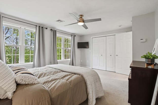 carpeted bedroom with a closet, ceiling fan, and baseboards