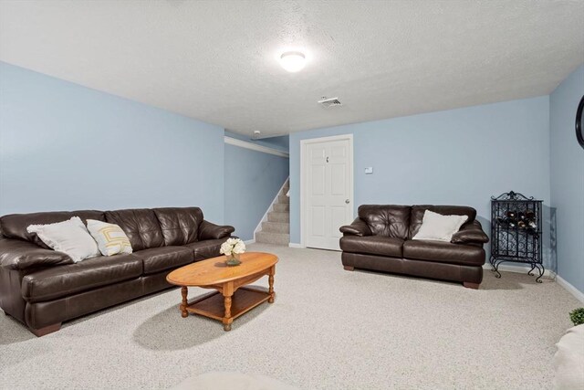 carpeted living room with baseboards, a textured ceiling, and stairs