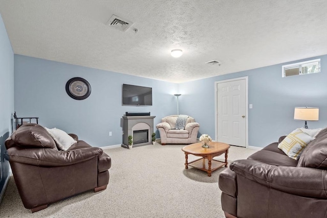living area featuring baseboards, carpet floors, a textured ceiling, and a glass covered fireplace