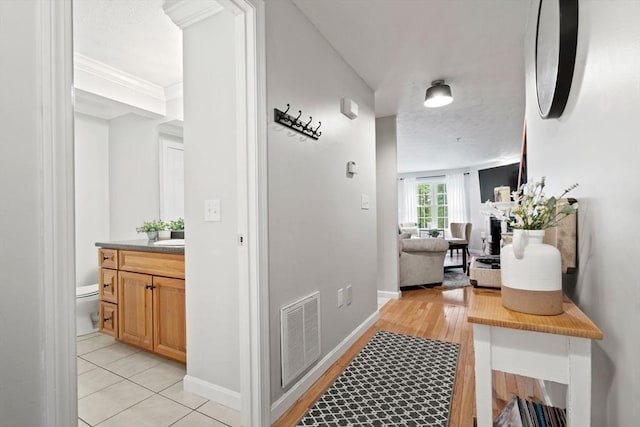 hall featuring baseboards and light wood-style flooring