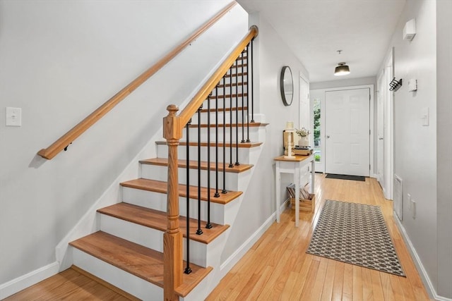 stairway featuring wood finished floors and baseboards