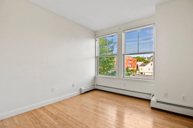 unfurnished room with a baseboard radiator and light hardwood / wood-style flooring