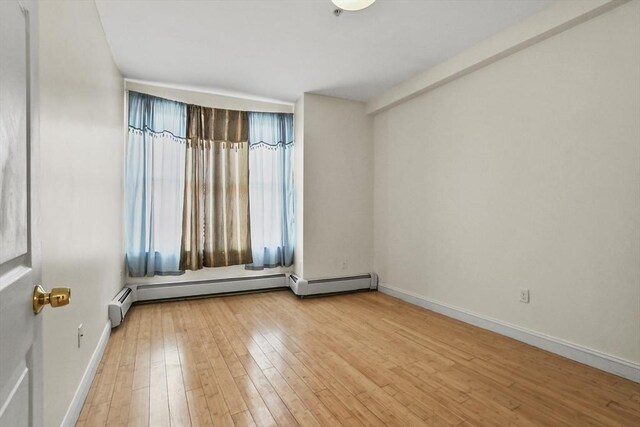 empty room with baseboards and hardwood / wood-style flooring