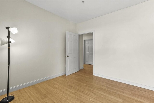 unfurnished room featuring light wood finished floors and baseboards