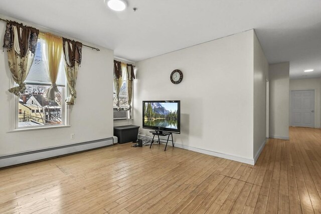 interior space with baseboards, cooling unit, hardwood / wood-style flooring, and baseboard heating